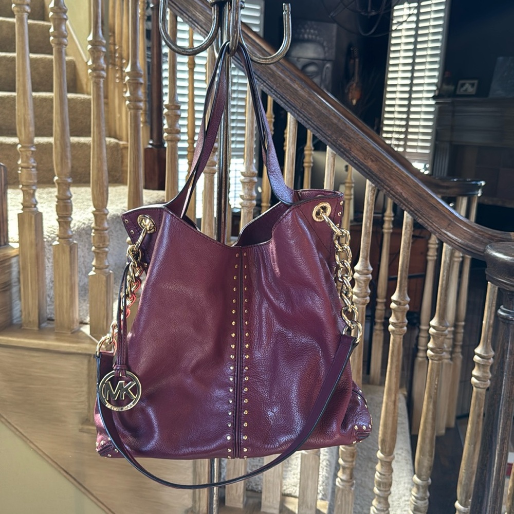 Michael Kors plum leather with gold accents studs and chain strap.